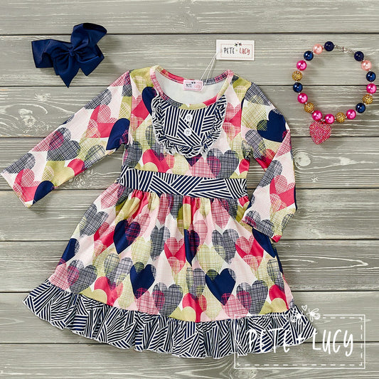 Look oh so pretty in this Geo-Hearts Long Sleeve Dress! Featuring a jewel neck line-bib front ruffle accent, ruffle hem and an undeniably stylish multi-heart print, it's sure to make them fall in love! We love the contrasting geo print. Who says style can't be comfy AND cute? Grab this dress and let the compliments roll in.