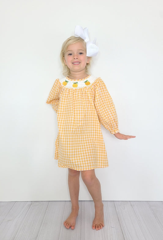 This classic Pumpkin Smocked dress is ideal for your little girl. It boasts a long sleeve adorned with elasticated wrist detailing, and the body is designed with a charming orange and white gingham print and a smocked neckline with embroidered pumpkin 🎃 motifs. Guaranteed to be a seasonal favorite!