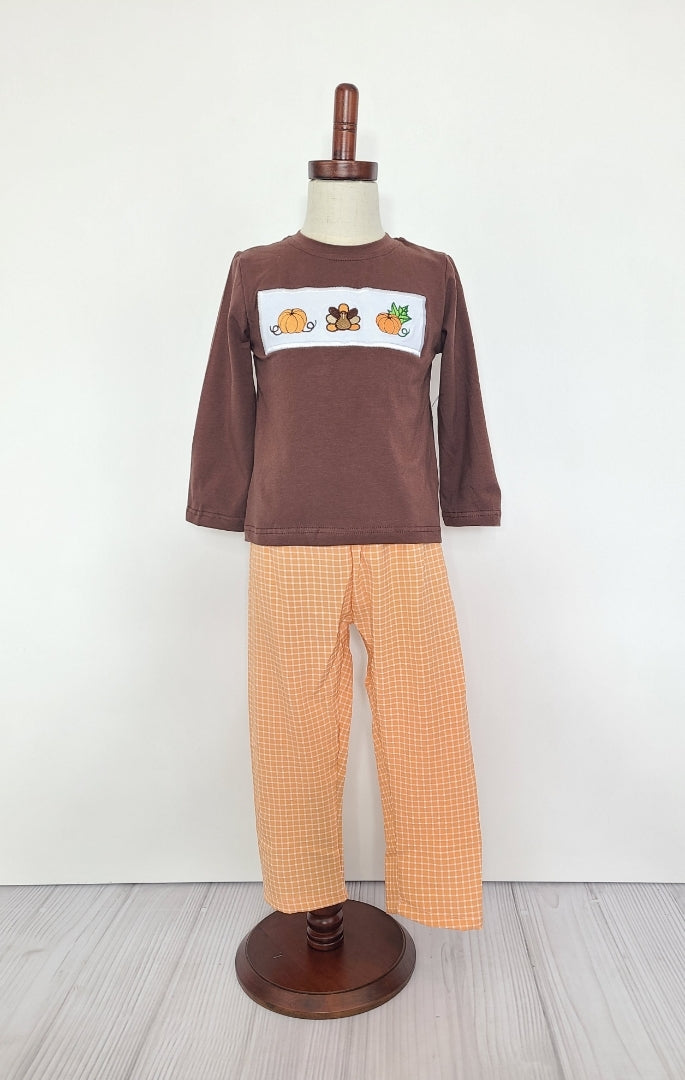 Look fall-fabulous in this Fall-loving 2 Piece Boys Set! This dark brown long sleeve shirt with pumpkin 🎃 and turkey 🦃 smocked applique will have them looking fly for the season. Paired with the orange and white seersucker pants, your little one will be the handsomest boy in town!