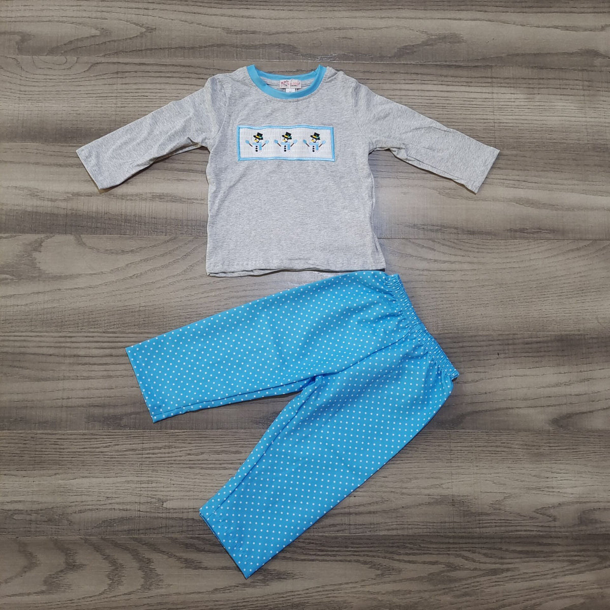 Look snow-cute in this Snowman Smocked 2-piece pant set - The light grey long sleeve shirt is made extra festive with a smocked snowman applique on the chest🤩! The cheerful blue print pant is dotted with white, just like a winter's dream ☃️. Get ready to snow-off your winter style in this one! 