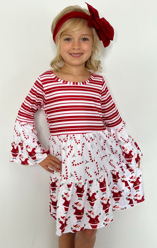 This Candy Cane-Santa Triple Ruffle Dress is a must-have for the holiday season. This adorable dress features a 3 pattern print of stripes, candy canes and Santa, a bell sleeve, and an elegant A-line design. Perfect for any little one this festive season! 🍭🎅