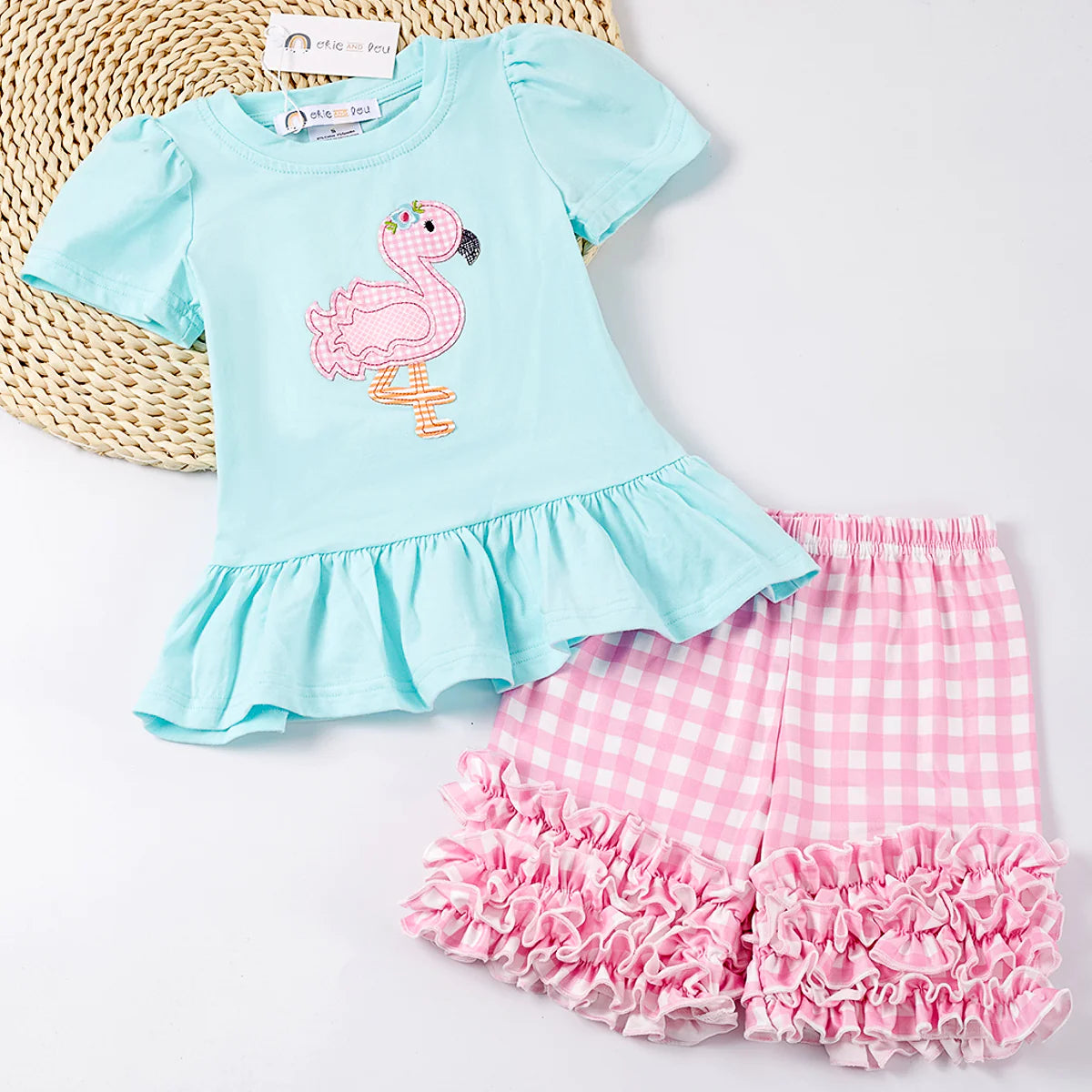 Get ready for fun in the sun with our Feisty Flamingo 2-piece Short Set! This sweet ensemble features an adorable top with a pink and white check Flamingo applique and a large ruffle hem, plus matching pink and white check shorts with a multi-ruffle hem. Let's Par-TAY like there's no tomorrow! Palm Beach, here we come!