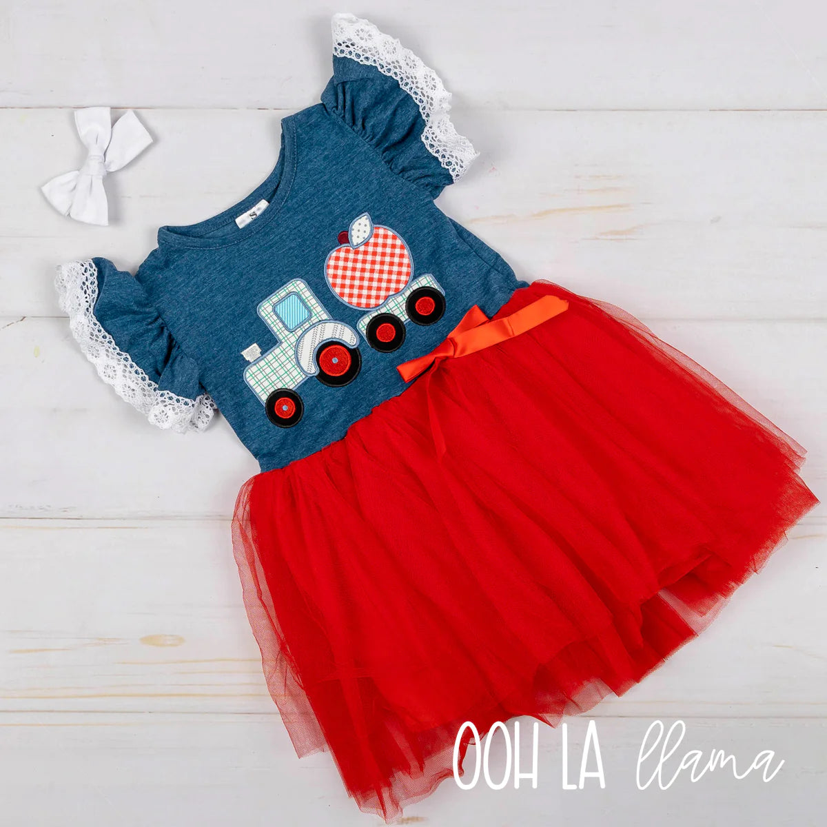Outfit your little one in this tractor-tastic outfit! With its checkered apple applique, short ruffle sleeves, and red tulle skirt, this adorable dress turns a back-to-school look into a fashion ride that won't crash and burn! Hop aboard and let the style adventure begin!