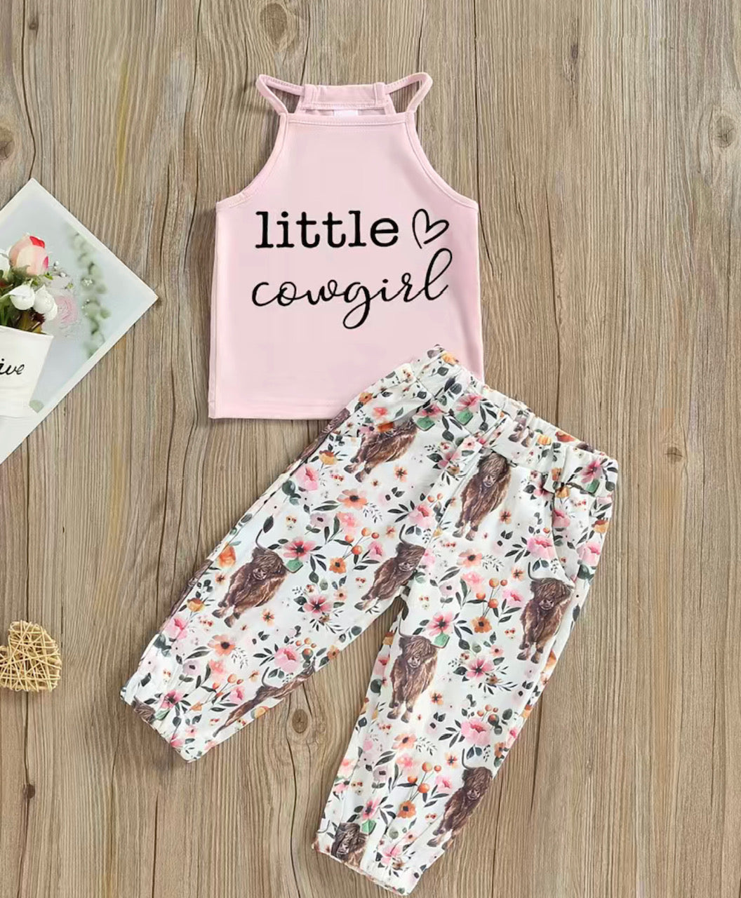 This Little Cowgirl- 2 Piece Pant Set will make your little one feel like the wild west! With a fun pink spaghetti strap top and adorable flower and cow print bottoms, your little cowgirl will be styling while she's ropin' and ridin'. Elastic waist and pockets make these comfy and functional for every day of adventuring. Yee-haw!