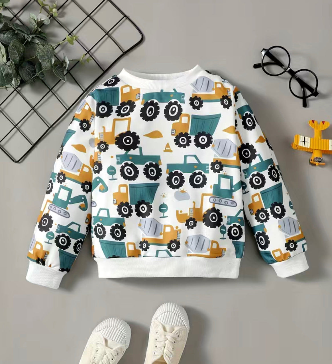 Rev up your little racer's wardrobe with these Trucks, Trucks and More Trucks Long Sleeve Shirt. This fun shirt features a multi-truck style print in neutral colors that'll have them lookin' sharp as they roll around town. With ribbed cuffs, waistband and collar, they'll be comfortable and stylish.🚚