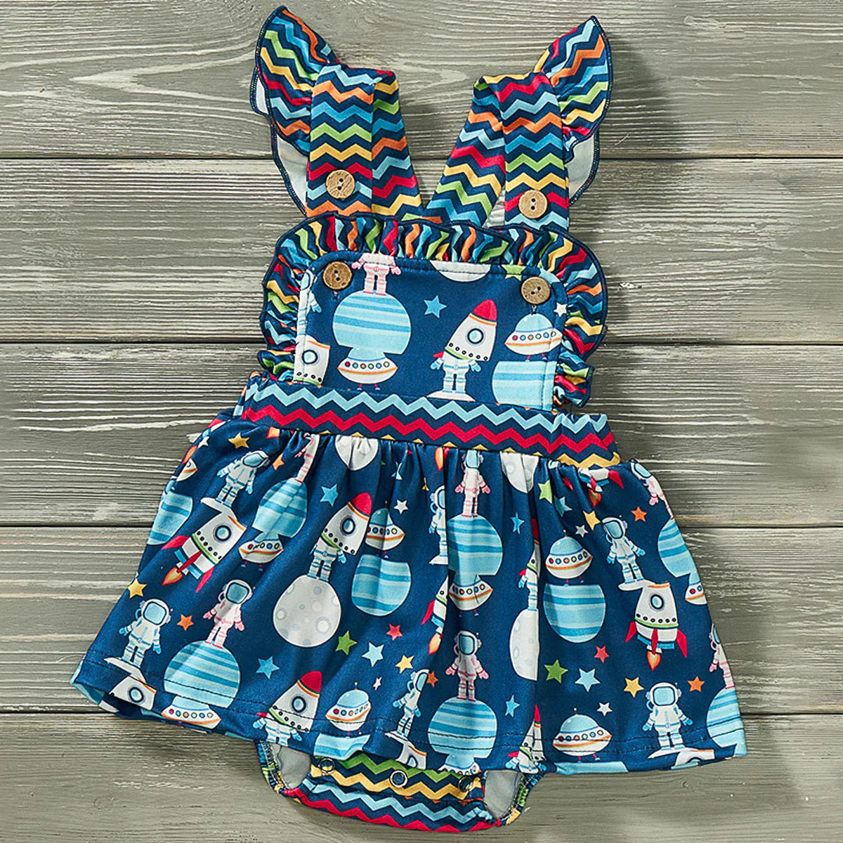 Watch your little girl head to infinity and beyond in this stylish Aliens and friends Girl's Halter Romper! With an out-of-this-world fabric design and multi-hued zig-zag fabric, she'll be the cutest alien in the universe. We love the square ruffle neckline and flutter sleeve!! The elastic waist and snap-up closure add convenience. Is she ready for a galactic adventure? Blast off!