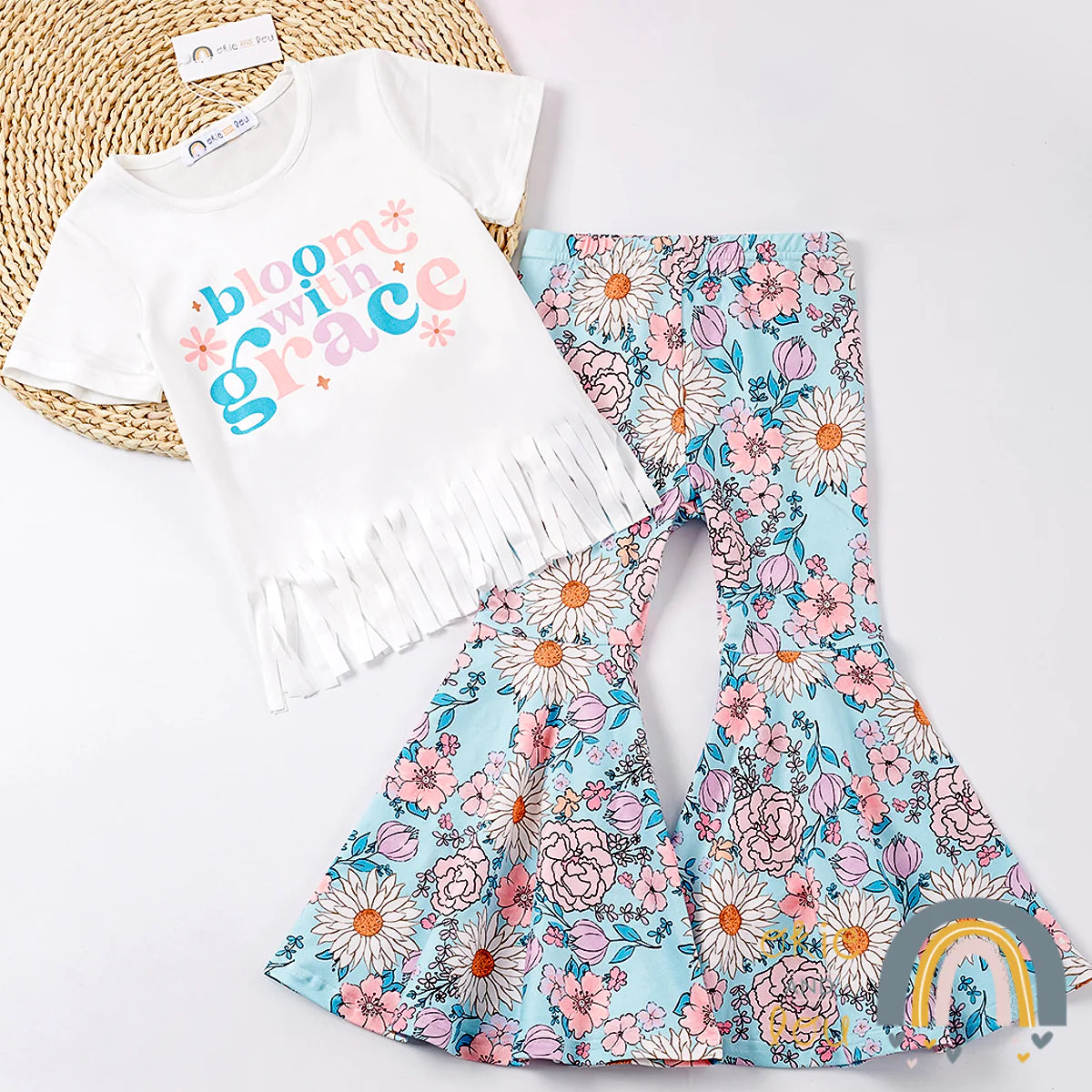 Look as groovy as a summer daisy in this two-piece Bloom with Grace pant set! The bell bottoms and fringe hem will take your style to new heights. The bright floral print is a sheer delight, guaranteed to make you the hippest chick in town. Come on, flower child, and bloom with grace!