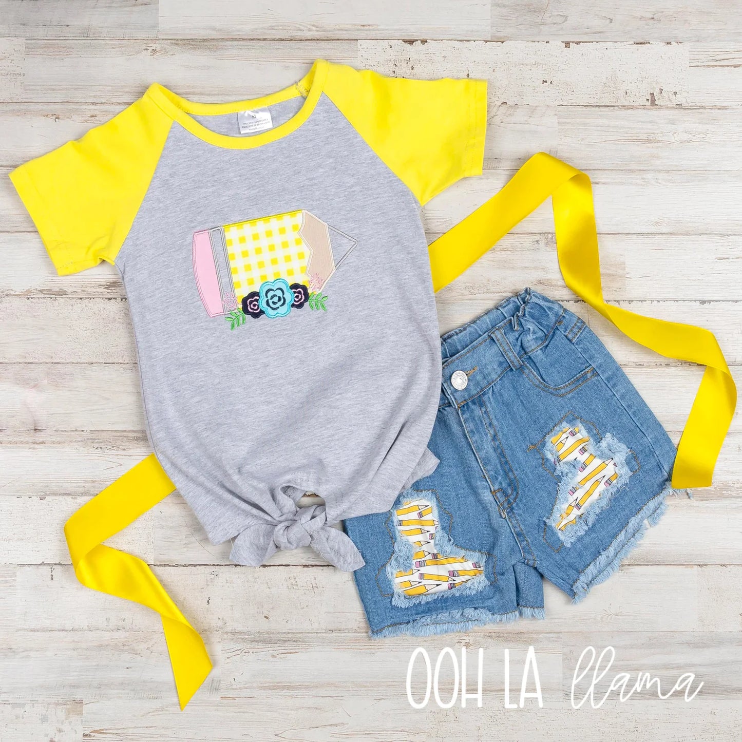 Make their playground style pop with our Pencils Galore Denim Short Set! This adorable ensemble features a whimsical pencil applique on a grey short sleeve shirt with yellow sleeves, along with denim shorts with multi-pencil patterned patches and a wide yellow ribbon belt, making their look stand out like a sharpened 2B!