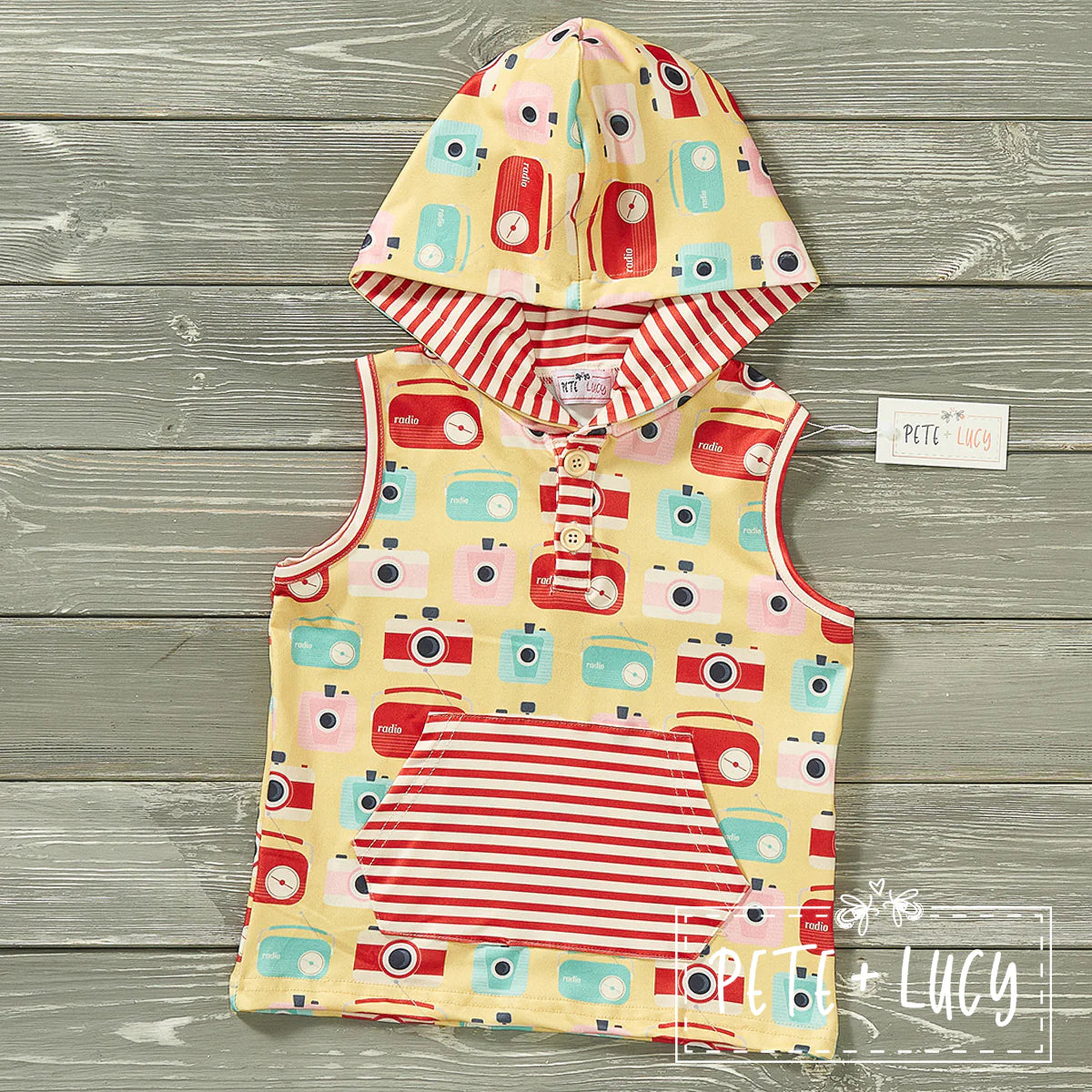 Let your little one feel the vintage vibes with this awesome retro hooded sleeveless shirt! With a classic hooded design and a playful vintage camera and radio print fabric, your kid will stay comfy & cool while looking like they just stepped out of a time machine! Plus, with an extra kangaroo pocket, they can store their loot with ease. Get ready to rock & roll! We love the contrasting red and white strip fabric on the pocket and inside the hood, on point!