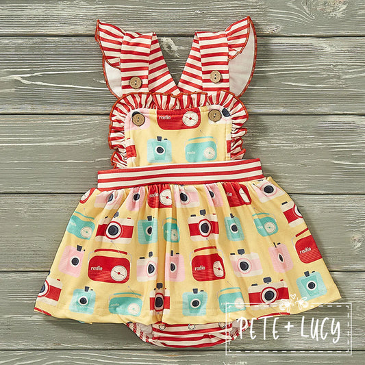 Looking for a picture-perfect romper for your little one? Look no further! Our retro girl halter back bubble romper is perfect for a day of lounging or playing! With an adorable vintage camera/radio print and contrasting red and white stripe fabrics, it'll elevate any outing! Plus, what's cuter than a flutter sleeve, square ruffled neckline,  and skirt accent. #MustHave!