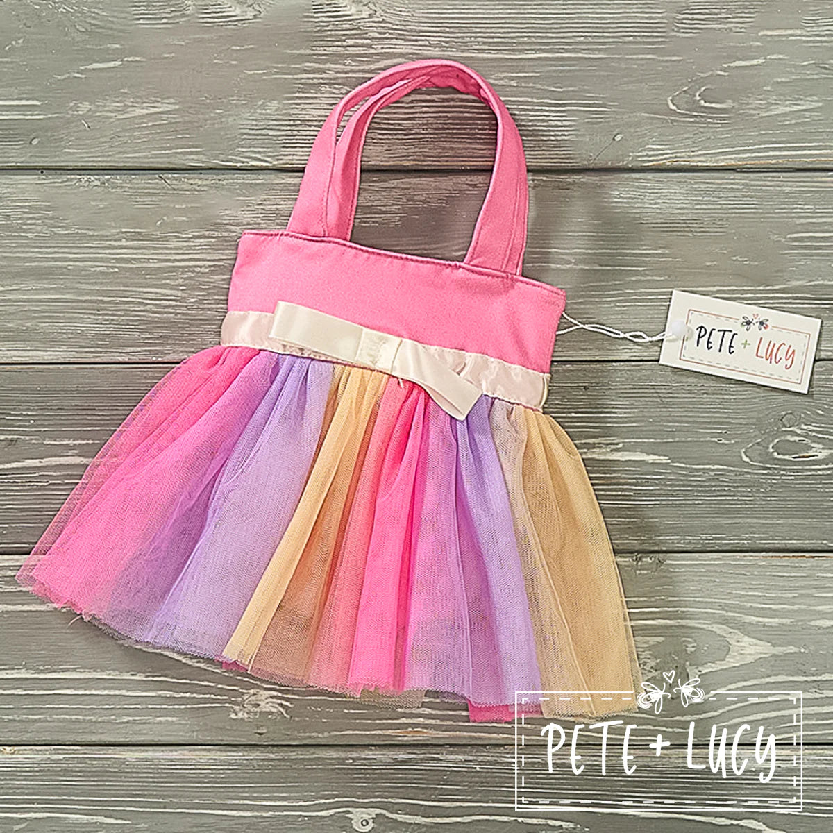 This Tu-Tu Good Tulle Bucket Purse is the perfect pick-me-up accessory for any outfit. Featuring vibrant colors of pink, purple and yellow, along with a bow accent, the tulle ruffles will have you feeling like a princess! With a 9/12 in strap, it's easy to carry around and with its 7 in width and 8 in length, you can fit all your essentials. Say "ta-da!" to Tu-Tu Good style. Check out the matching tulle skirt!