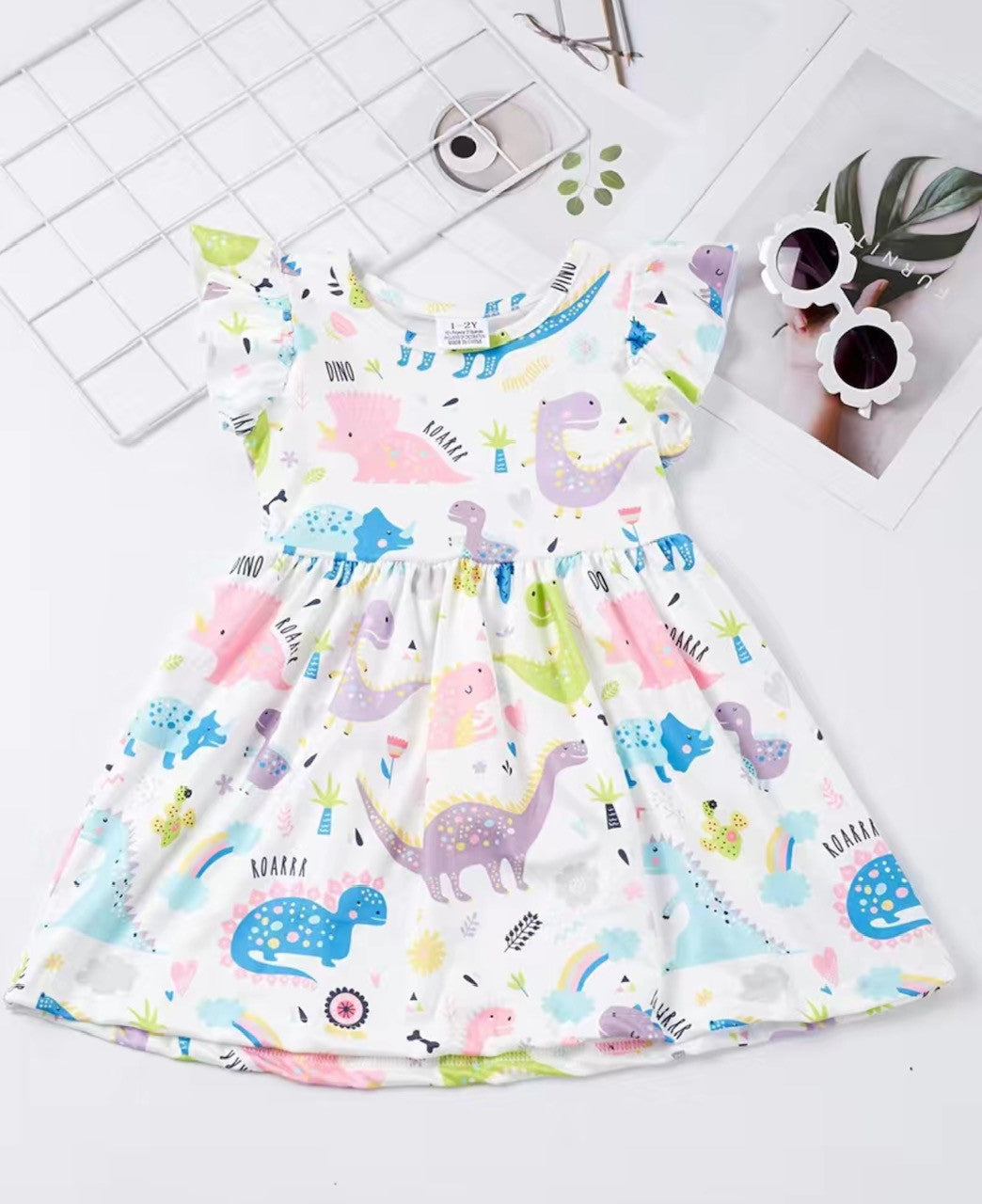 Make a fashion statement with this unique and charming Pastel Dinosaur Dress! With a round neck and fluttery sleeves, you'll feel absolutely dino-mite in this super soft milk silk fabric-- perfect for taking your look to a whole new prehistoric level. Plus, its adorably cute pastel dinosaurs will have all your friends roaring with excitement!