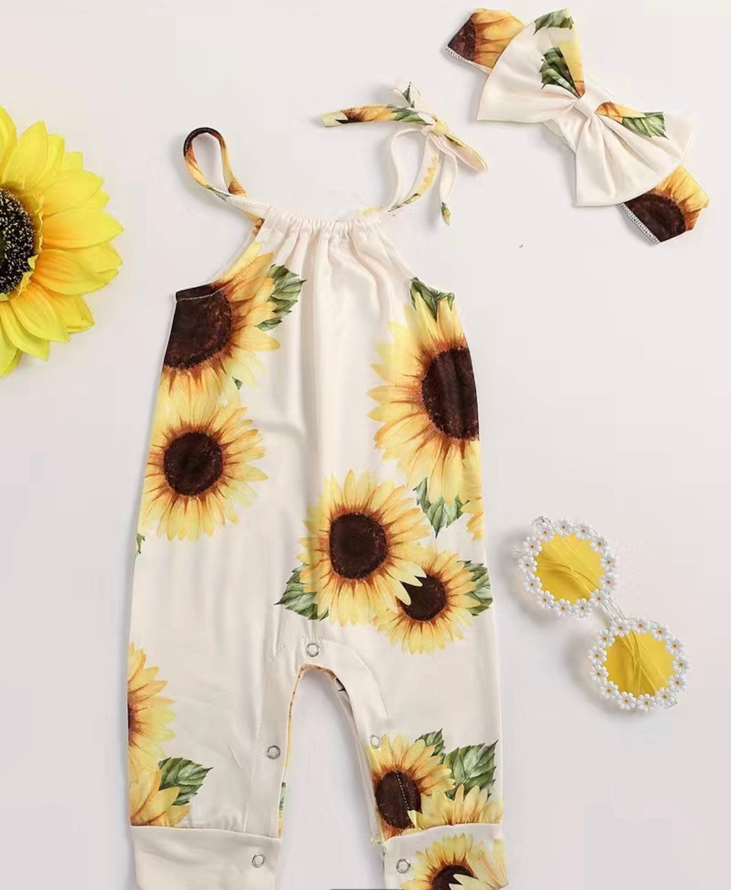 Look adorably chic in this head-turning sunflower romper! With its adjustable straps, snap crotch, and matching headband bow, you'll be ready for a sunny day in no time! Get your summer glow on with this cute look- it'll put a sunny glow on everyone's face! :)