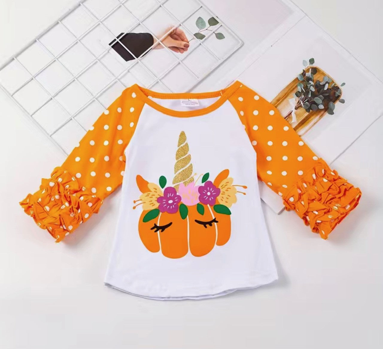 Fall in love with this Pumpkin Unicorn Ruffle Raglan Shirt! With its Oh-So-Cute pumpkin sporting a sassy unicorn horn and floral headdress, this Orange ruffle sleeve raglan will have you tickled pink (or orange!). Soft, comfy, and oh-so-stylish, it's the perfect piece for any child's wardrobe!