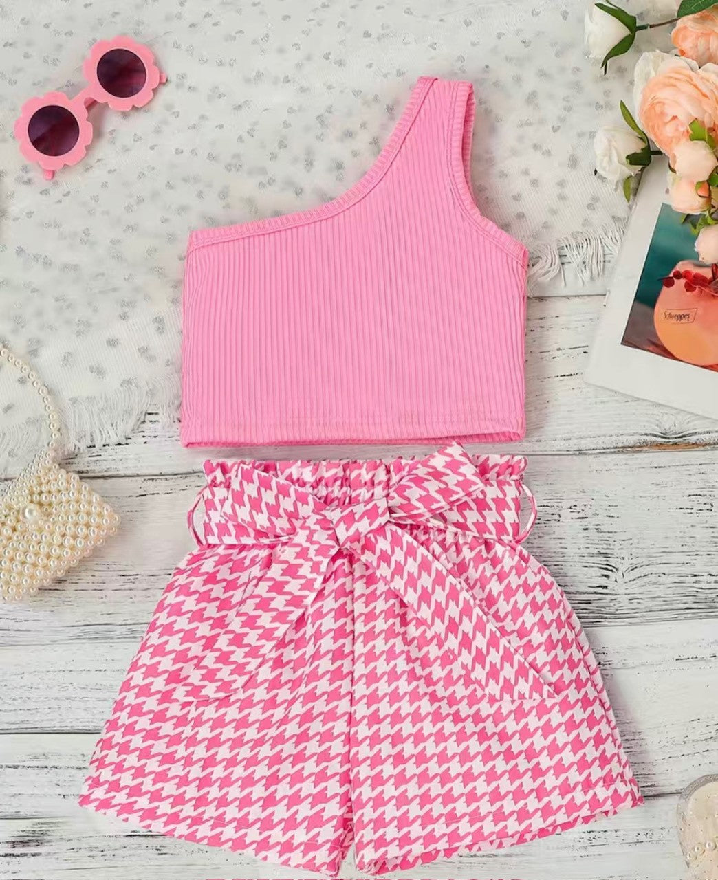 Make a statement with this 'Perfect in Pink' two-piece set. Show off your girly style in the one shoulder, ribbed sleeveless top paired with the houndstooth print shorts and matching belt. Who says you can't look cute and comfortable? P.S. Pink is definitely your color!