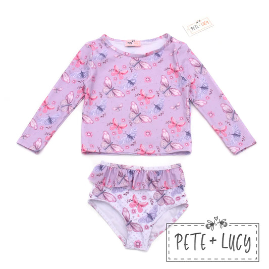 Designed for sun and water protection, the Lilac Butterflies swimsuit w/ rashguard features a two-piece design with long sleeves and a ruffle bottom. The Lilac butterfly pattern is so pretty and gives UPF 50+ protection in and out of the water. Splash, dive, and swim in style and protection.