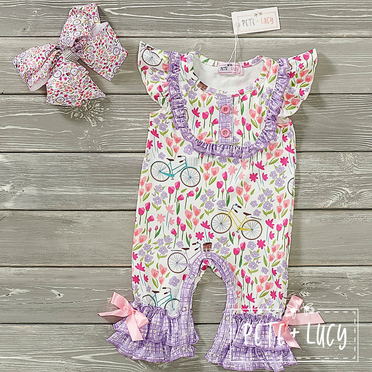 Loving this adorable romper! The fabric combination of bicycles and tulips in contrast with the lavender check print is precious. We love the double ruffle hem and bow at the ankle as well as the ruffle trim on the chest and the sweet ruffled sleeve. We can't wait to see this precious romper on your little beauties this spring and summer!