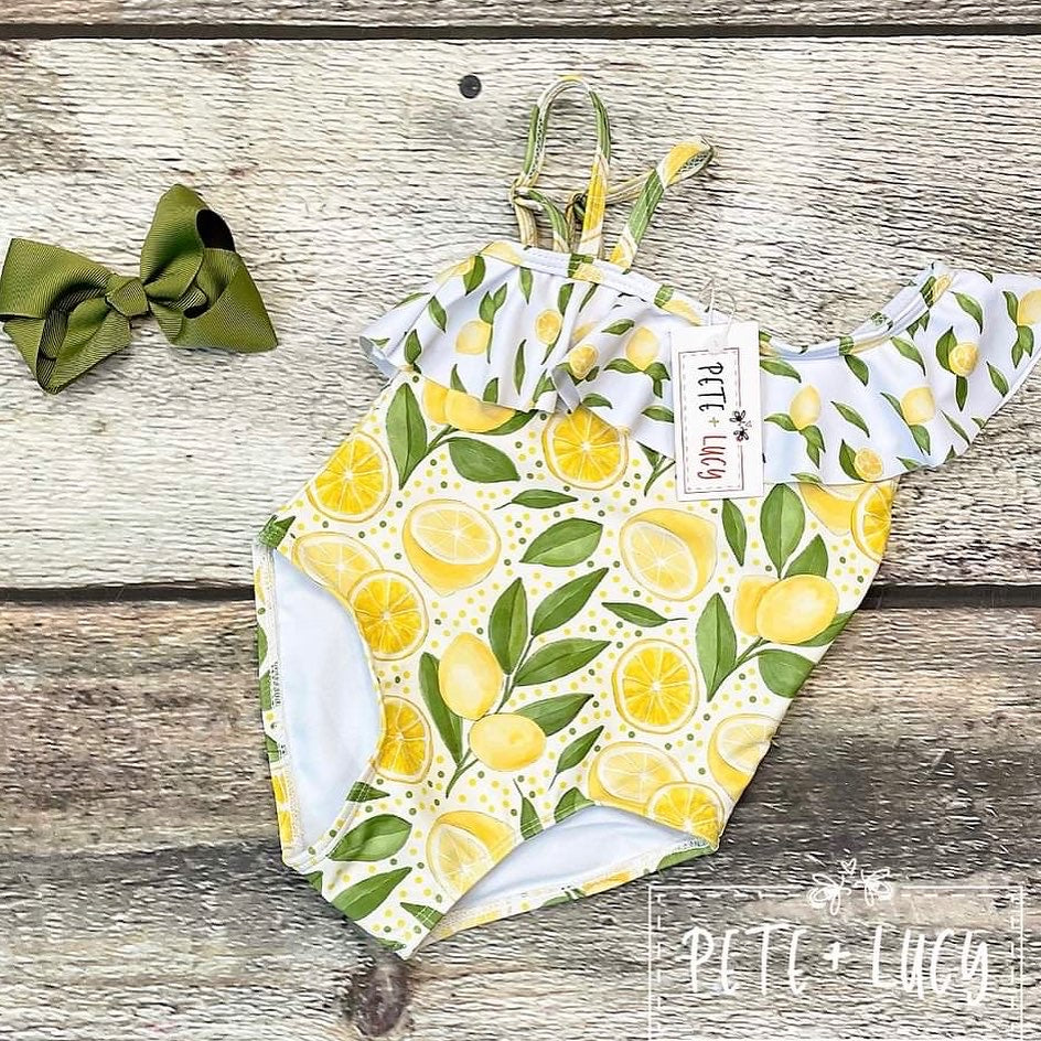 Mellow Lemon 1 piece Swimsuit offers a stylish look with a fun and playful twist. The adorable swimsuit offers a shoulder ruffle for a look that is both captivating and timeless. Perfect for summer days spent at the beach or pool, this cheerful swimsuit is sure to make a splash.