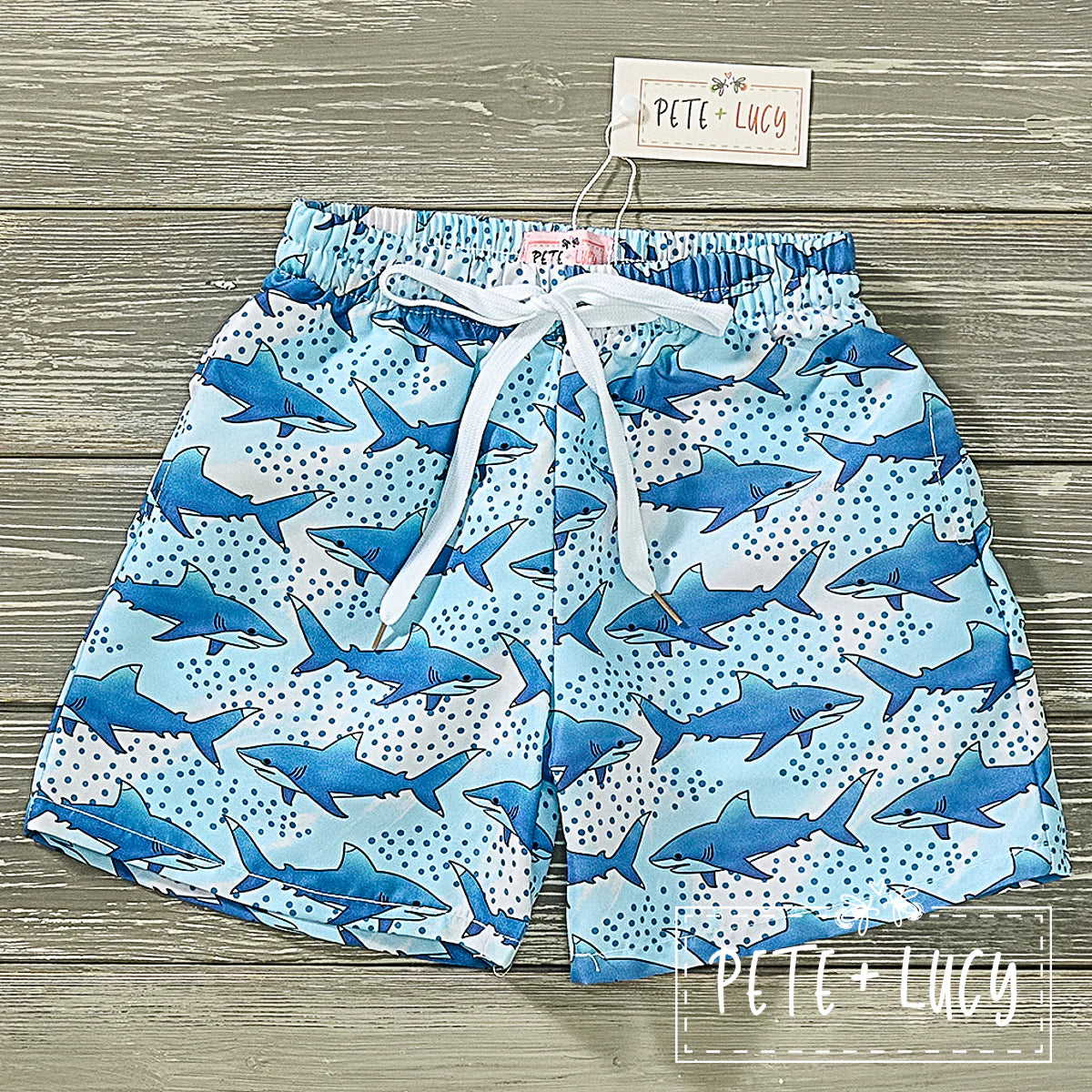 Let your little one swim with the sharks in style with these Shark Frenzy Boy's Swim Trunks! Constructed with a garterized waistband and drawstring, these lined swim shorts will keep them secure and comfy while they're at play in the sea. Also equipped with UPF 50 sun protection. A must this spring/summer!