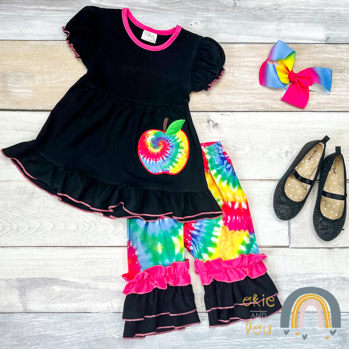 This adorable back to school inspired pant set is one of our staff picks for the season! The scoop neck top has hot pink trim on the ruffled hem and sleeve and is paired with the adorable tie die ruffle bottom pants. Love this!!