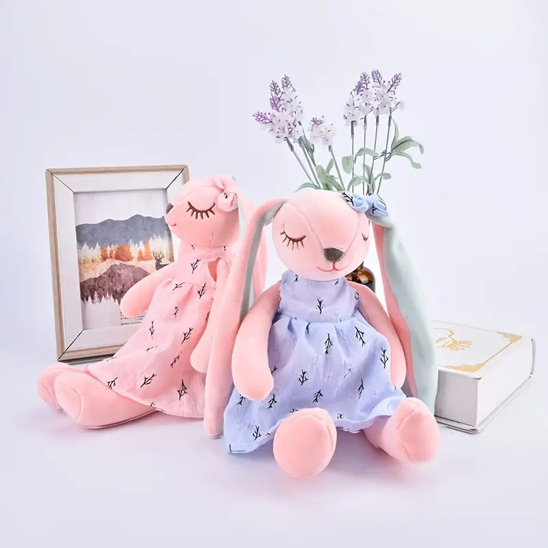 This adorable floppy eared bunny stands 13.7 inches tall. The bunny is adorned with a cute dress and matching bow on the ear. The perfect friend for your little guy or gal! Comes in both a pink or blue dress.
