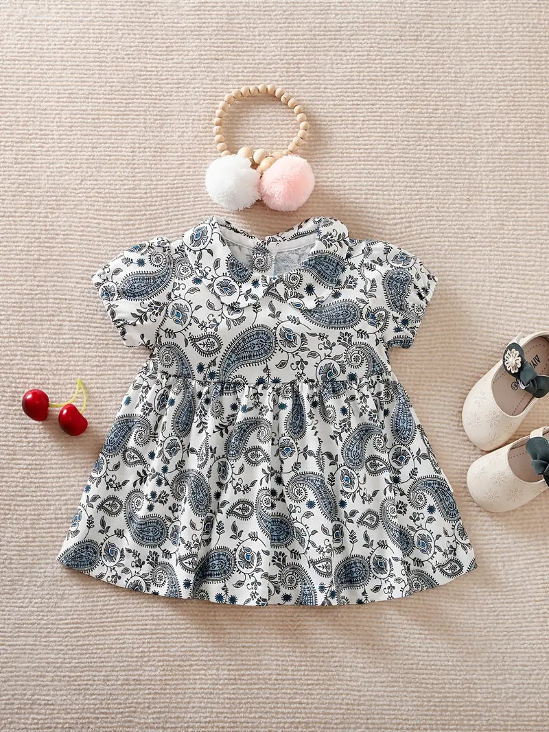 This beautiful paisley print slate grey, blue and white dress is the perfect addition to your little girls wardrobe this season. We love the capped sleeve and collared neckline, so sweet!!