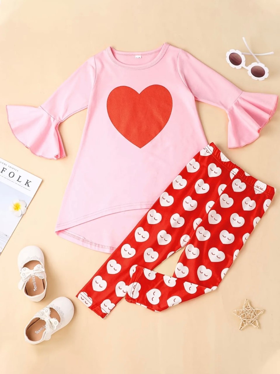 This adorable 2 piece pant set has our hearts fluttering. We love the adorable heart pattern on the elastic waist pant, as well as the bell sleeve and hi-low top with the single large heart! So adorable for your little Valentine, or any time of the year. 